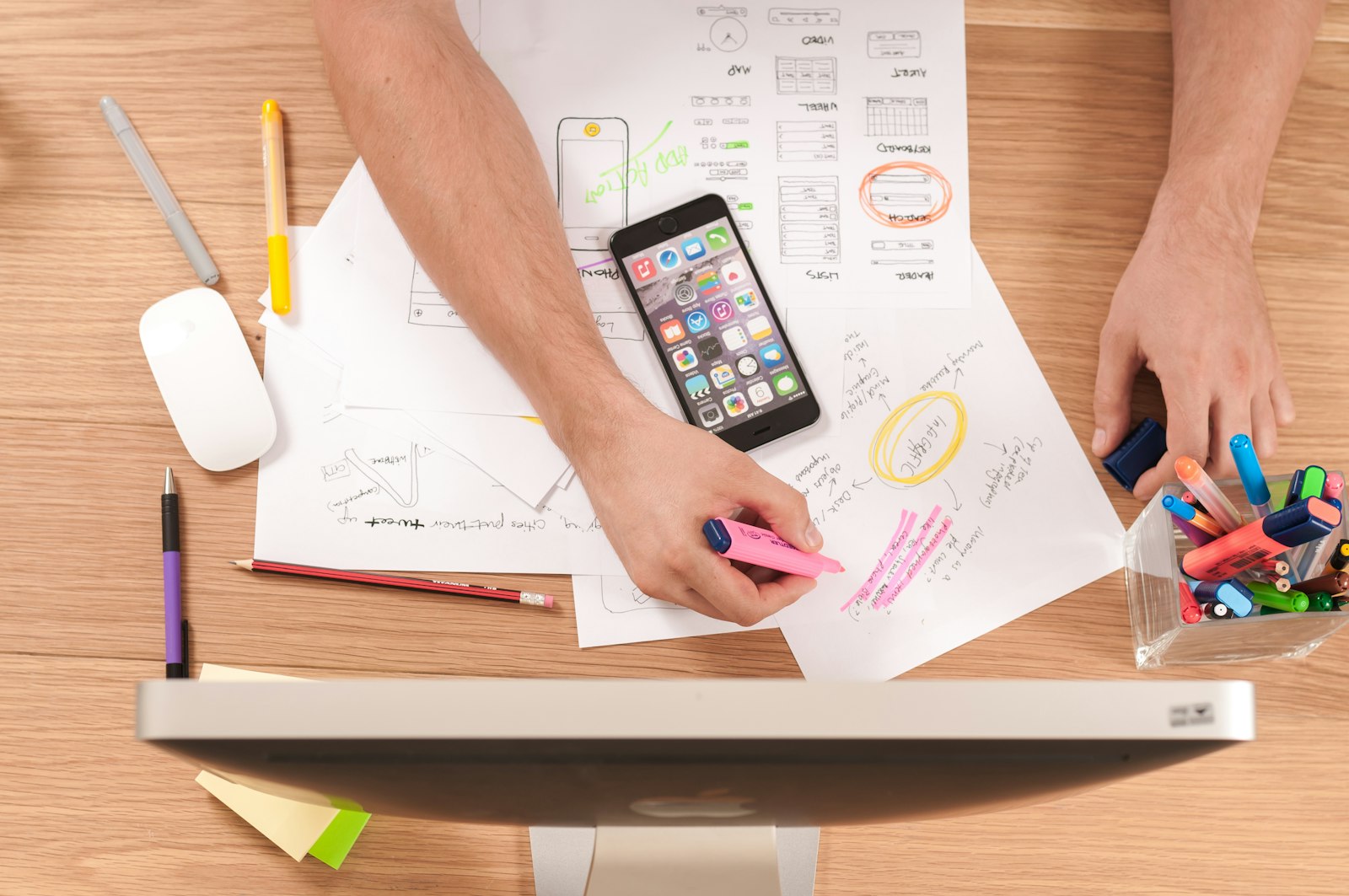 Planning social media content on paper, with a phone on the desk